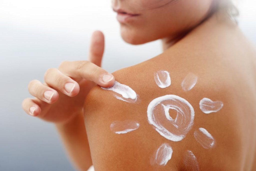 a woman applying sunscreen 1024x683